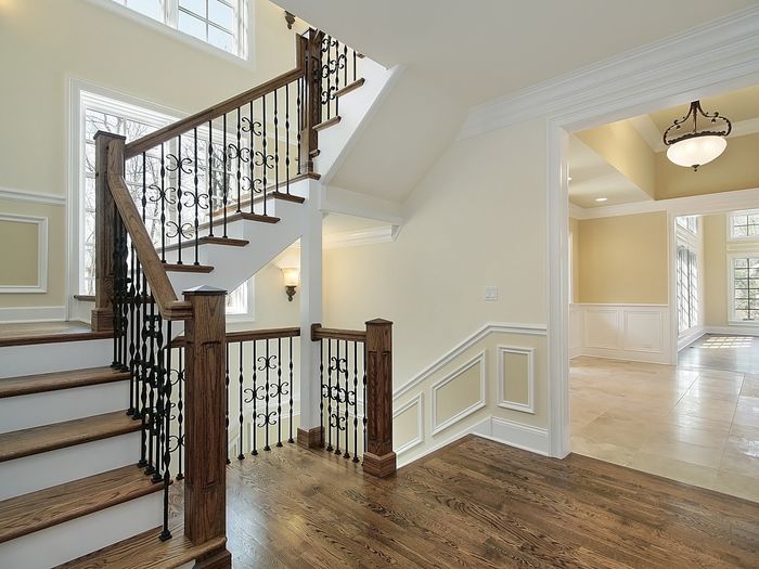 A curved staircase with wood treads and iron spindles, the stair work most flooring crews subcontract out